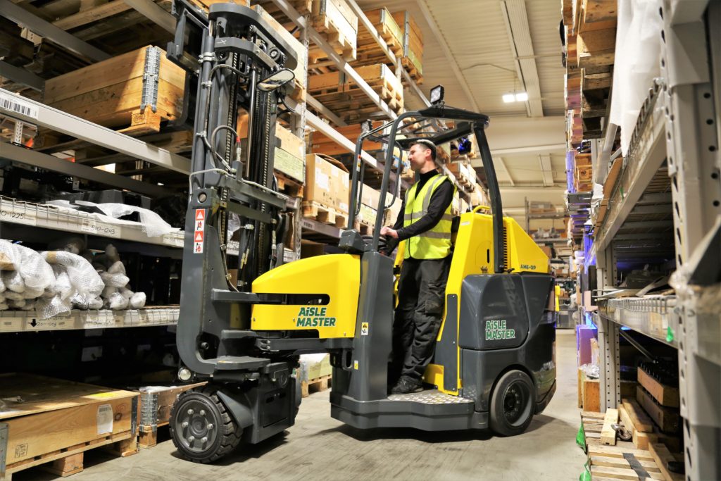 Aisle Master Order Picker (AME-OP) Worker in high-vis operating the Aisle Master Order Picker for Multihog